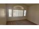 Bedroom with large windows, neutral colored walls and neutral colored carpet at 1325 Fiesta Grande Ct, North Las Vegas, NV 89031