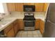 Kitchen area features stainless steel appliances, tile floors and light wood cabinets at 1325 Fiesta Grande Ct, North Las Vegas, NV 89031