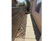 Narrow sideyard featuring a concrete pathway and rock bed at 1325 Fiesta Grande Ct, North Las Vegas, NV 89031