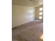 Open-concept living room featuring neutral color palette, carpet flooring, and natural light at 1413 Bryn Mawr Ave, Las Vegas, NV 89102