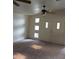 Bright living room features vaulted ceiling, carpet, and unique windows flanking the front door at 1413 Bryn Mawr Ave, Las Vegas, NV 89102