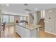 Open kitchen featuring a granite island, white cabinets, and access to the living area and stairs at 156 Campbelltown Ave, Henderson, NV 89015