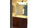 Bathroom featuring a dual sink vanity, a well-lit mirror, and wood cabinets at 167 Desert Pond Ave, Henderson, NV 89002