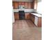 Kitchen featuring tile floors, wooden cabinets, modern appliances and a window for natural light at 167 Desert Pond Ave, Henderson, NV 89002