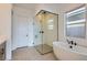 Bathroom featuring a freestanding tub, glass shower enclosure, and large window at 182 Robledo St, Las Vegas, NV 89138