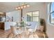 Elegant dining area with a round glass table, modern chandelier, and bright window at 182 Robledo St, Las Vegas, NV 89138