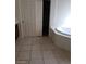 Bathroom showcasing tile flooring, a sliding door closet, and a corner tub at 206 Valerian St, Henderson, NV 89015