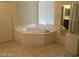 Bathroom with a corner tub, window with blinds, and a tiled floor at 206 Valerian St, Henderson, NV 89015
