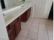 Bathroom featuring a double sink vanity with dark wood cabinets and neutral tile flooring at 206 Valerian St, Henderson, NV 89015