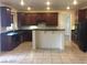 Well-appointed kitchen with dark cabinetry, black appliances, and a breakfast bar at 206 Valerian St, Henderson, NV 89015