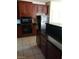 Close-up of a kitchen, showing dark countertops and cabinets, and black appliances at 206 Valerian St, Henderson, NV 89015