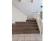 Carpeted staircase featuring white banisters and tiled floors at the base at 206 Valerian St, Henderson, NV 89015
