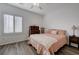 Cozy bedroom with wood-look flooring, neutral walls, plantation shutters, and a comfortable bed at 2261 Evening Lights St, Henderson, NV 89052