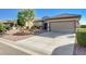 This single-story home features a two car garage and mature landscaping in the desert landscaped front yard at 2261 Evening Lights St, Henderson, NV 89052