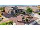 Charming single-story home with desert landscaping, featuring mature trees and manicured flower beds, enhancing curb appeal at 2261 Evening Lights St, Henderson, NV 89052