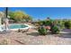 Lush backyard landscaping featuring pavers, rocks, and vibrant rose bushes, creating a tranquil and inviting outdoor space at 2261 Evening Lights St, Henderson, NV 89052