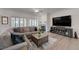 Spacious living room showcasing a gray sectional, light wood floors, and a fireplace with TV above at 2261 Evening Lights St, Henderson, NV 89052