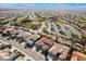 High angle neighborhood shot of homes with terracotta roofs in a planned community with trees and green spaces at 2365 Black River Falls Dr, Henderson, NV 89044