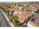 Aerial view of the house with a terra cotta roof in a neighborhood with mature trees and swimming pools at 2365 Black River Falls Dr, Henderson, NV 89044