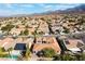 An aerial view shows a desert community of single-Gathering homes with terracotta roofs nestled in the mountains at 2365 Black River Falls Dr, Henderson, NV 89044