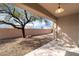 Tranquil backyard setting with desert landscaping, mature trees, and a covered patio at 2365 Black River Falls Dr, Henderson, NV 89044