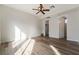 Spacious bedroom featuring wood-look floors, ceiling fan, and two entrances to other rooms at 2365 Black River Falls Dr, Henderson, NV 89044