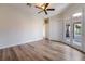A spacious bedroom featuring wood-look floors, a ceiling fan, and outdoor access at 2365 Black River Falls Dr, Henderson, NV 89044