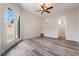 Bright bedroom featuring wood-look floors, ceiling fan and glass patio doors to outside at 2365 Black River Falls Dr, Henderson, NV 89044