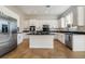 Bright kitchen featuring white cabinets, stainless steel appliances, a black countertop island, and tile flooring at 2365 Black River Falls Dr, Henderson, NV 89044