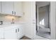 Bright laundry room featuring white cabinets, stainless sink, and access door to outside at 2365 Black River Falls Dr, Henderson, NV 89044