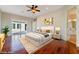 Staged bedroom with hardwood floors, a ceiling fan, and access to a bathroom and backyard, perfect for relaxation at 2365 Black River Falls Dr, Henderson, NV 89044