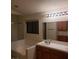Bathroom boasts a shower-tub combo and a well-lit vanity with a large mirror and wooden cabinets at 2720 Knightsbridge Rd, Henderson, NV 89074
