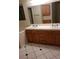 Bathroom featuring a double sink vanity with wood cabinets, a large mirror, and tile flooring at 2720 Knightsbridge Rd, Henderson, NV 89074