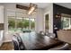 Bright dining area with backyard views, dark wood table, stylish chairs, and modern lighting at 2785 Rosenhearty Dr, Henderson, NV 89044
