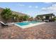 Backyard pool and outdoor kitchen area with elegant seating and mature landscaping at 2785 Rosenhearty Dr, Henderson, NV 89044