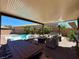 Relaxing covered patio featuring a dining area, seating, and a view of the backyard pool oasis at 2785 Rosenhearty Dr, Henderson, NV 89044