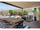 Inviting covered patio with comfortable seating, a dining table, and a view of the pool area at 2785 Rosenhearty Dr, Henderson, NV 89044
