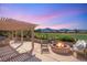Spacious back patio featuring a pergola, outdoor kitchen, fire pit, and views of the golf course at 2917 Golf Links Dr, Las Vegas, NV 89134