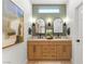 Updated bathroom with double vanity, wood cabinets, modern fixtures, decorative mirrors, and wood flooring at 2917 Golf Links Dr, Las Vegas, NV 89134