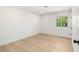 Bright, minimalist bedroom with hardwood floors and a window view of greenery at 2917 Golf Links Dr, Las Vegas, NV 89134