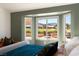 Bright bedroom featuring a bay window with views of the landscaped backyard and mountain range at 2917 Golf Links Dr, Las Vegas, NV 89134