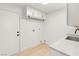 Functional laundry area with overhead storage, utility sink, and ample counter space at 2917 Golf Links Dr, Las Vegas, NV 89134