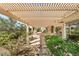 View of the outdoor kitchen area and pergola, with lush landscaping, that is perfect for relaxing outdoors at 2917 Golf Links Dr, Las Vegas, NV 89134