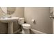 Compact bathroom features a pedestal sink, toilet, and neutral decor at 3045 Camino Rico Ave, Henderson, NV 89044
