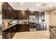 Spacious kitchen features dark wood cabinetry, stainless steel appliances, and granite countertops at 3045 Camino Rico Ave, Henderson, NV 89044