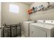 Functional laundry room equipped with a washer, dryer, and shelving for storage at 3045 Camino Rico Ave, Henderson, NV 89044