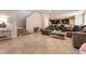 Living room with tile flooring flowing into a modern kitchen with dark cabinets and an island at 3045 Camino Rico Ave, Henderson, NV 89044