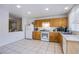 Well-lit kitchen featuring wooden cabinets, tile flooring, and modern appliances at 320 Ellen Marie Dr, Las Vegas, NV 89110