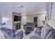 Cozy living room featuring tile flooring and comfortable gray reclining sofas at 320 Ellen Marie Dr, Las Vegas, NV 89110