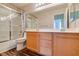 Bright bathroom featuring a double vanity, framed mirror, and a shower-over-tub with glass doors at 3336 Hidden Ridge St, Las Vegas, NV 89129